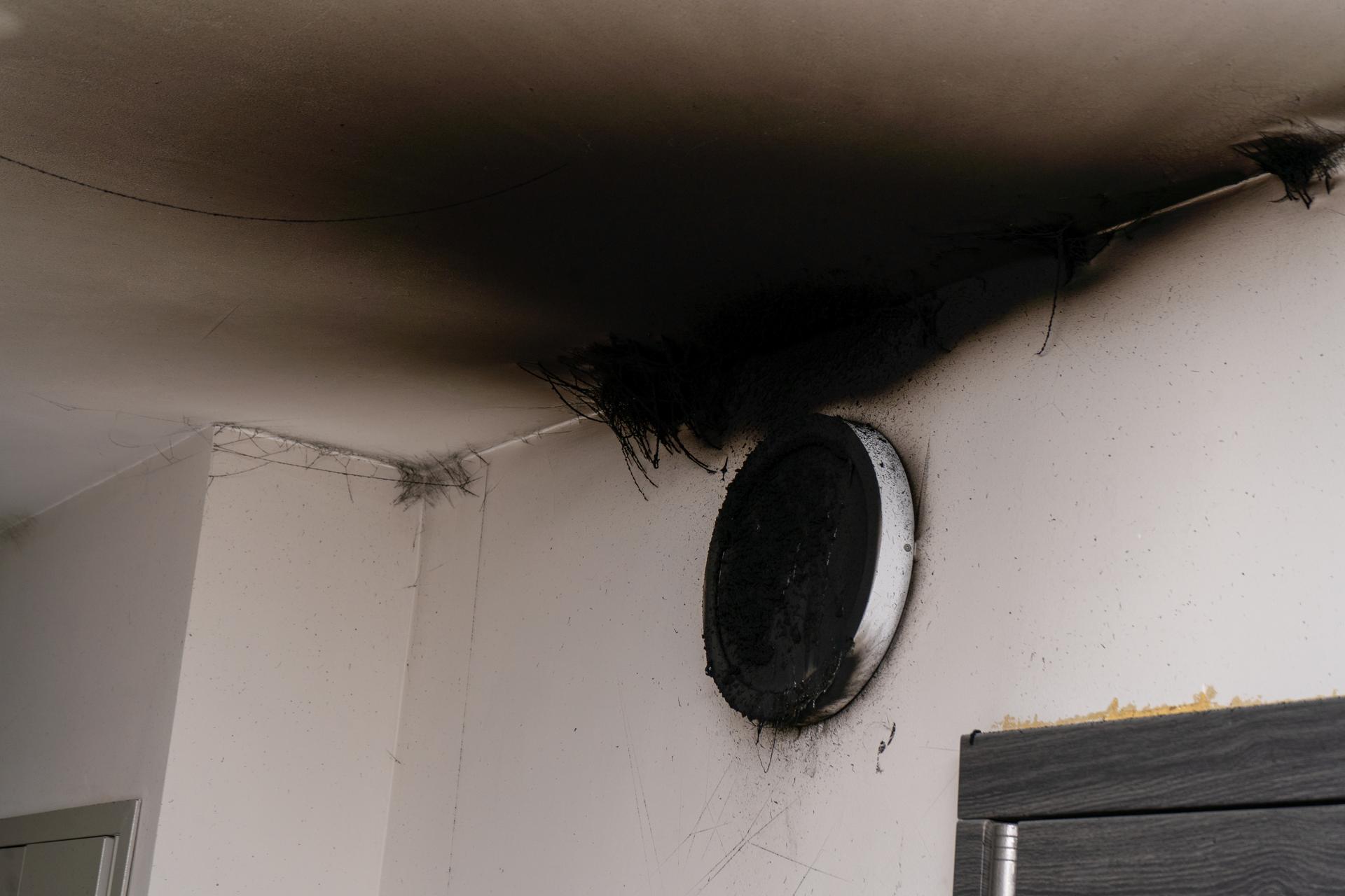 Burnt out LED lamp. A lampshade lamp on the wall after a fire. Spontaneous combustion and fire in a residential building.